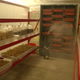 he growing room is a plastic tent with a humidifier pumping out moisture. Plastic containers contain straw from agricultural waste, which have been inoculated with mycelium to make wood-like planks and sheets.